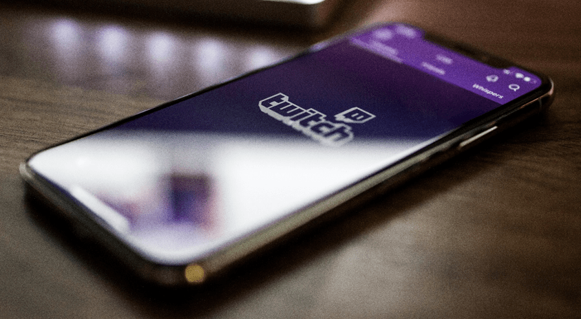 A photo of a mobile phone which has the Twitch.tv app open that has the Twitch.tv logo.
